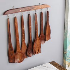 wooden utensils hang on the wall with hooks