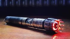 a close up of a flashlight on a wooden table with red light coming from it