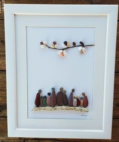 a group of rocks sitting on top of a wooden table next to a white frame