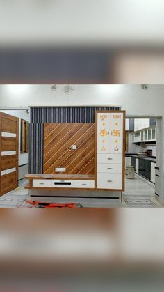 an empty room with wooden doors and drawers on the floor, in front of a wall