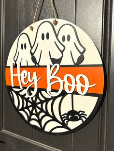 a sign that says hey boo with two dogs hanging from it's front door