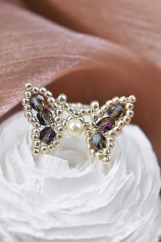 a close up of a ring with pearls and stones on top of a white flower