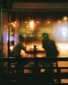 two people sitting at a table in the rain