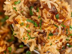 a spoon full of rice and meat with parsley on top