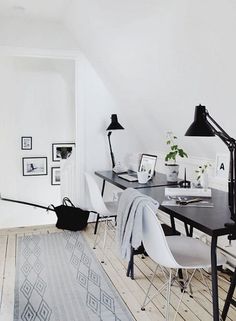 an image of a room with white walls and black furniture on the floor, including a desk