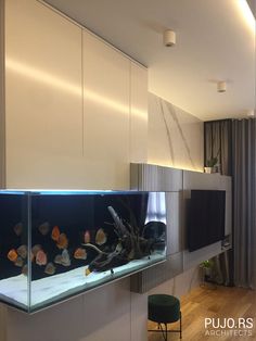 a fish tank in the middle of a living room next to a wall mounted tv