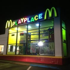 a mcdonald's at night with neon lights on the front and windows lit up