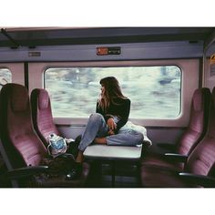 a woman sitting on a train looking out the window