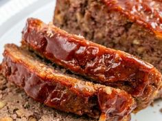 two slices of meatloaf on a plate next to some breadcrumbs