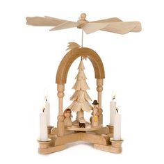 a small wooden christmas tree with angels in front of it and three candles on the bottom