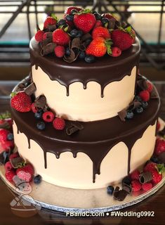 two tiered cake with chocolate and strawberries on top