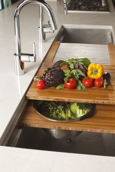 some vegetables are sitting on a cutting board in the sink