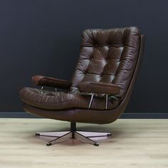 a brown leather chair sitting on top of a hard wood floor