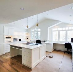 an empty kitchen with white cabinets and wood flooring is pictured in this image, there are no people or objects on the counter