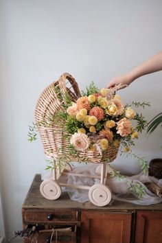 a wicker baby carriage with flowers in it