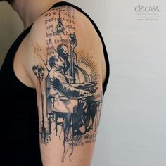 a man with a tattoo on his arm is playing the piano while another person watches