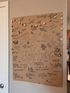 a bulletin board with writing on it in a kitchen next to a door and refrigerator