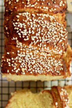 two loaves of bread with sesame seeds on top and one loaf cut in half