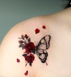 a woman's shoulder with a butterfly and roses tattoo on her left side breast