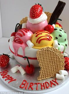 a birthday cake decorated with ice cream and strawberries