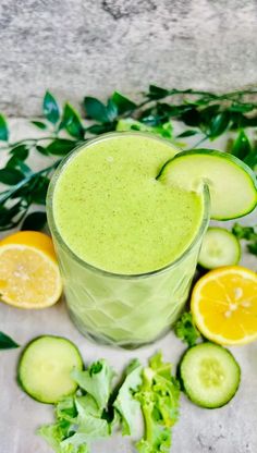 a green smoothie with cucumbers, lemons and lettuce on the side