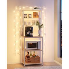 a white microwave oven sitting on top of a wooden shelf next to a wall with christmas lights