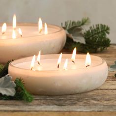 several lit candles sitting on top of a wooden table