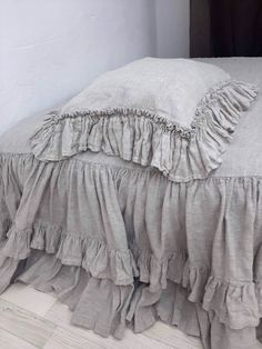 the bed is made up with ruffled linens