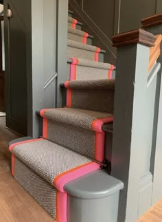 a set of stairs with pink and grey carpet