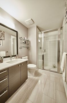 a bathroom with a sink, toilet and shower in it's own area is shown