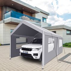 a white car is parked in front of a house with a gray awning on it