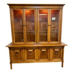 a wooden china cabinet with glass doors and drawers