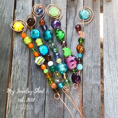 a bunch of glass beads sitting on top of a piece of wood next to a wire