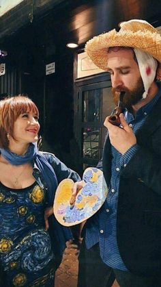 a man in a straw hat eating something next to a woman wearing a blue dress