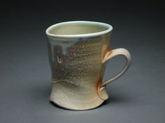 a white and orange coffee cup sitting on top of a table