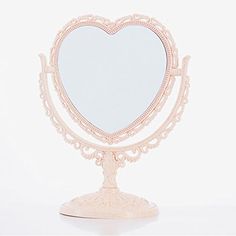 a heart shaped mirror sitting on top of a stand