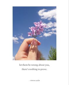 a hand holding a flower with the words let them be wrong about you, there's nothing to prove