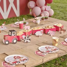 a table set up for a farm birthday party with plates, cups and desserts