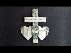 an origami cross made out of dollar bills with the words in god we trust written on it