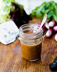 a jar filled with brown liquid sitting on top of a wooden table