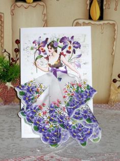 a card with an image of a woman in a dress and flowers on the front