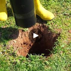 a person in yellow rubber boots standing next to a hole with a black tube on it