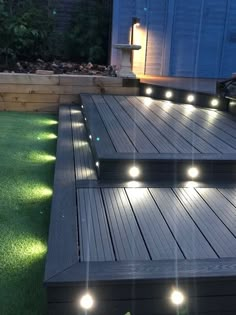 some lights that are on the side of a wooden deck