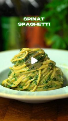 a white plate topped with pasta and spinach