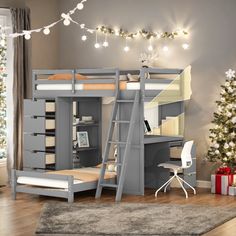 there is a loft bed with stairs to the top and desk below it, next to a christmas tree