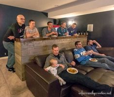 a group of men sitting on couches in a living room with food and drinks