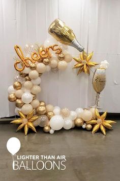 the balloon arch is decorated with gold and white balloons