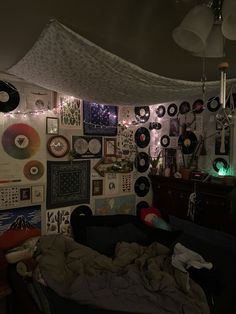 a room filled with lots of different types of records on the wall and lights hanging from the ceiling