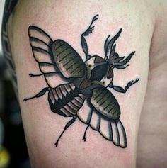 a close up of a tattoo on the arm of a person with a bee on it