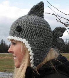 a woman wearing a crocheted hat with a shark design